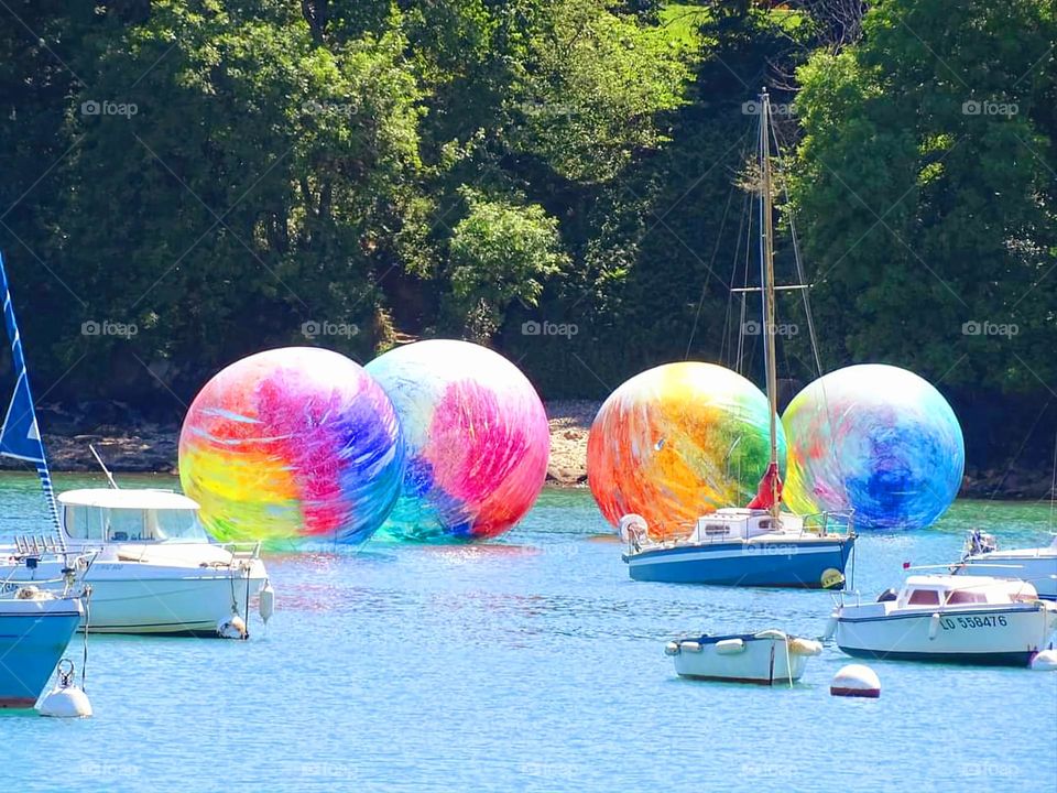 Huge colourful balls amongst sailing ships in Rosmeur port in Douarnenez