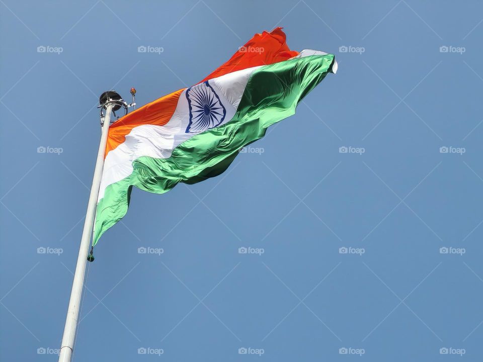 Indian flag high and brightly lit with sunlight