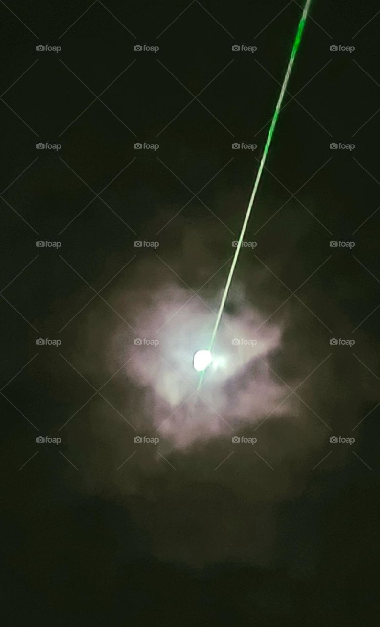 Laser beam passing in front of the moon.