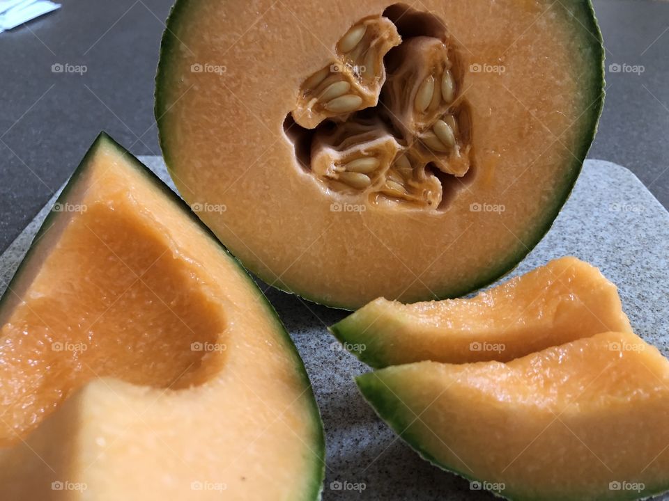 Cantelope cut up, wedges and half with the seeds still in orange flesh