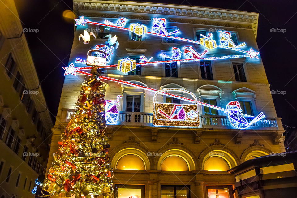 Christmas Tree In Front Of A Christmas Decorated Building
