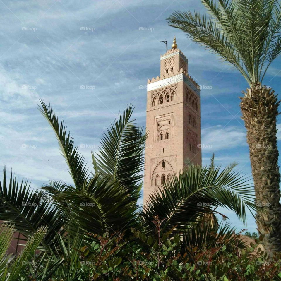 Beautiful minaret mosque and palm trees at marrakech city in Morocco.