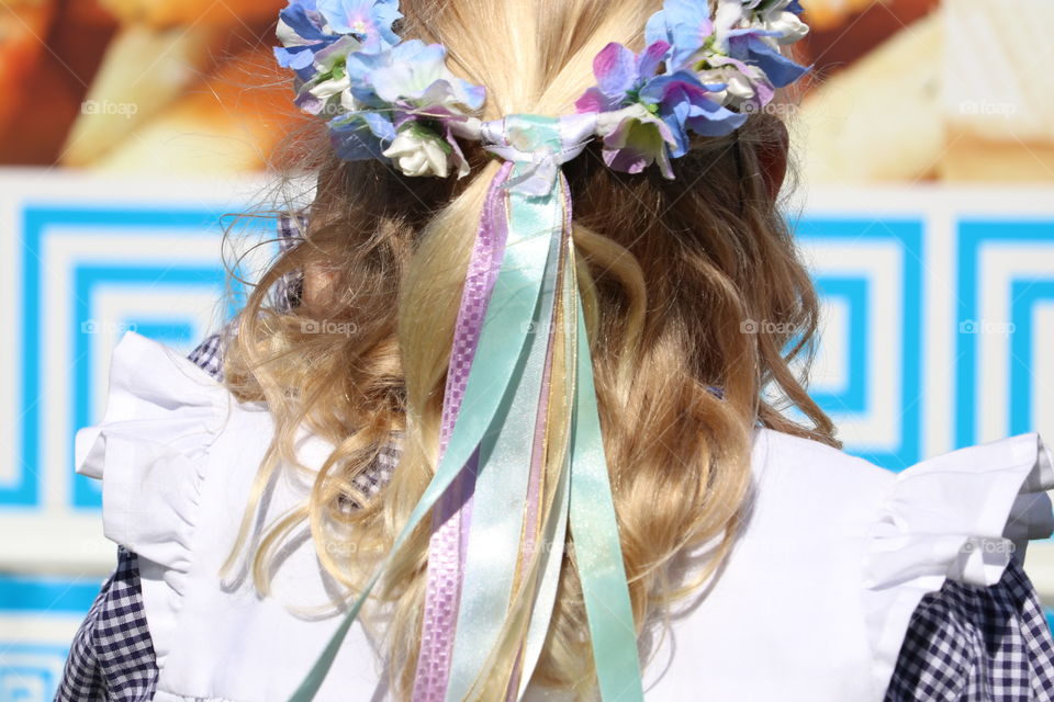 Flower crown on head of blond girl at outdoor festival fair 