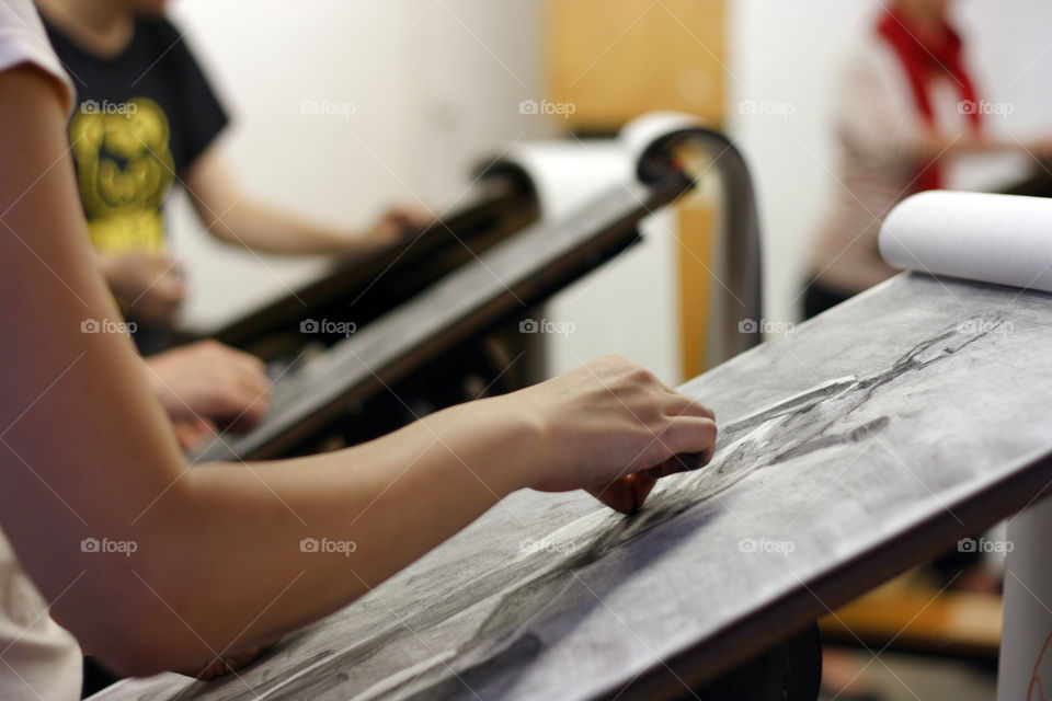 An artist sketches a model in the studio