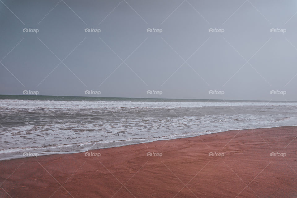 Beach with red sand like the land of the planet Mars