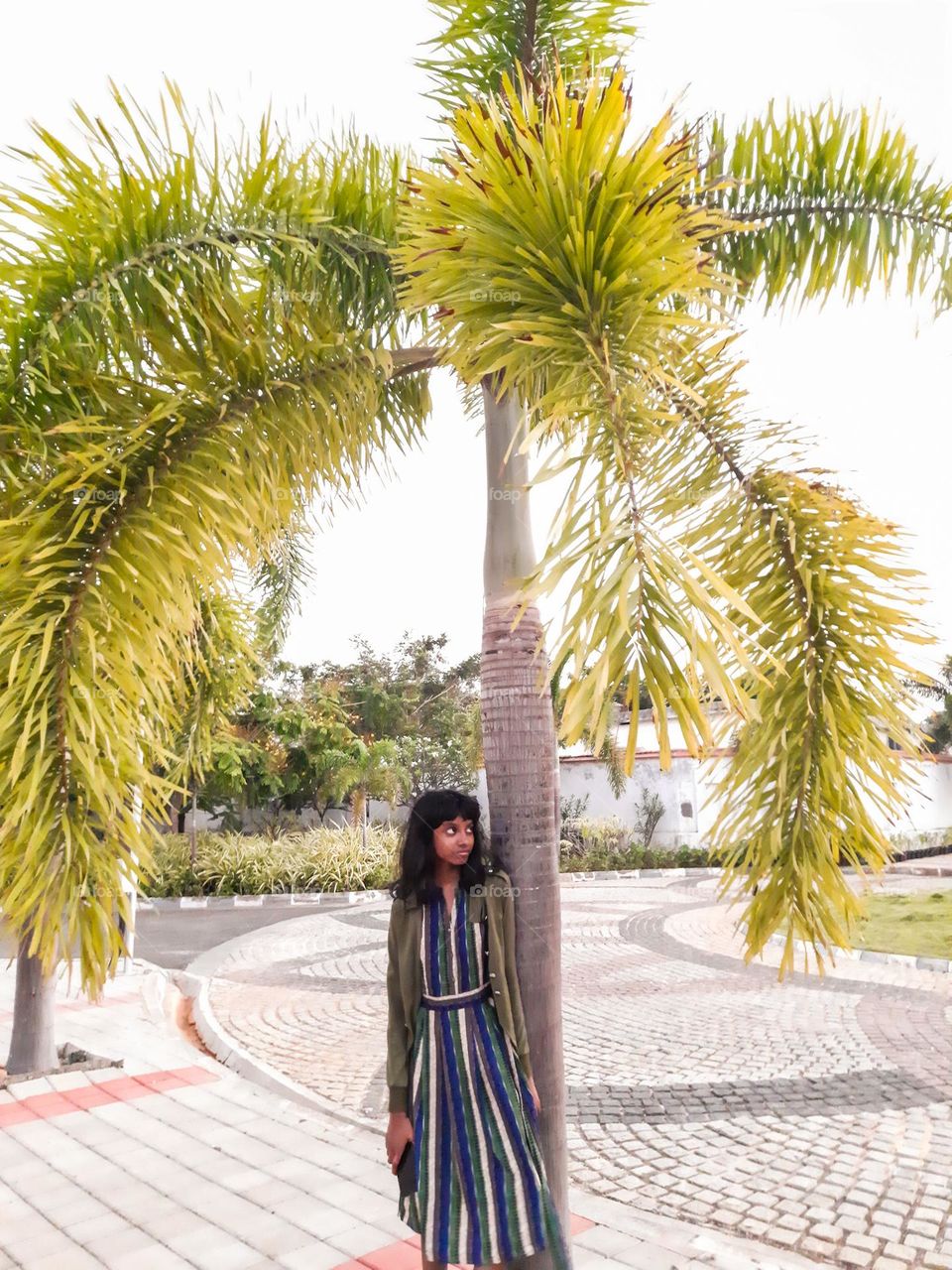 A girl standing under a tree