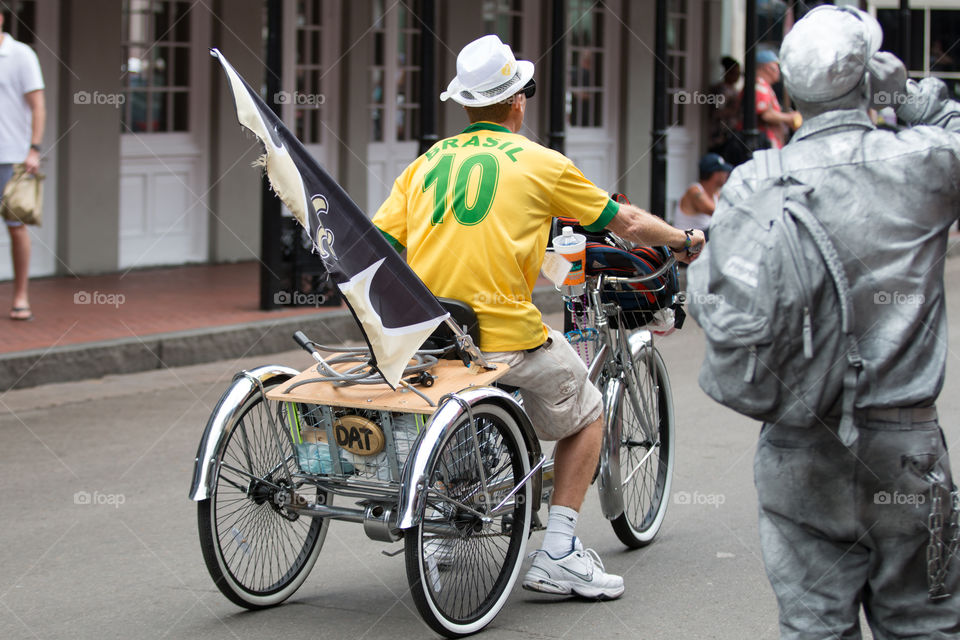 Man ride a tricycle with the flag to promote the event 