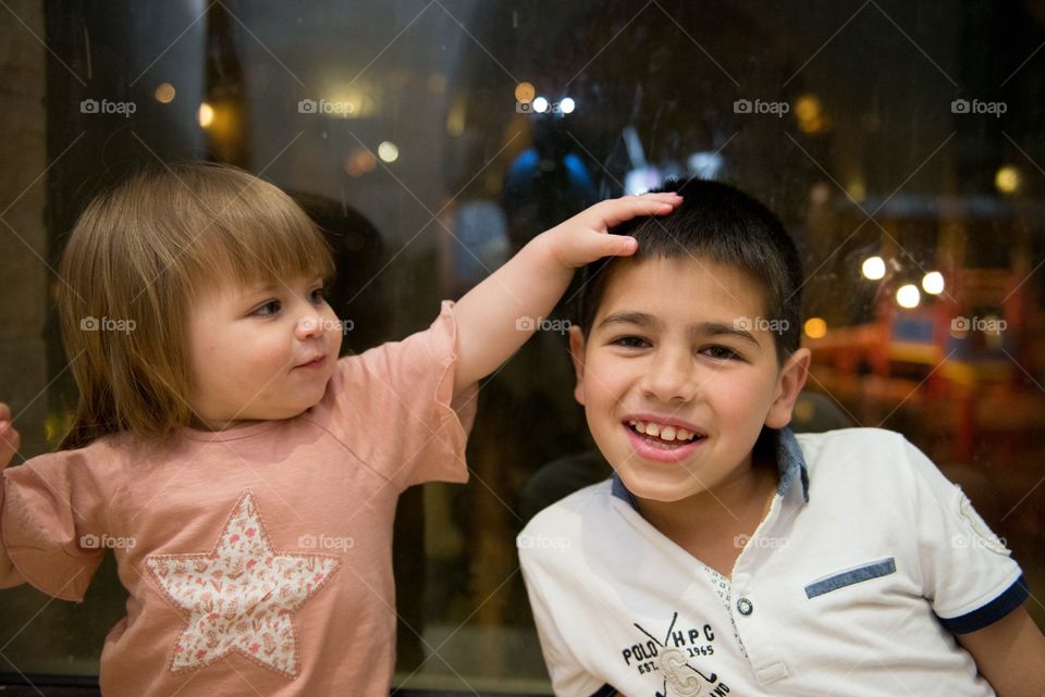 baby girl playing with her brother's hair