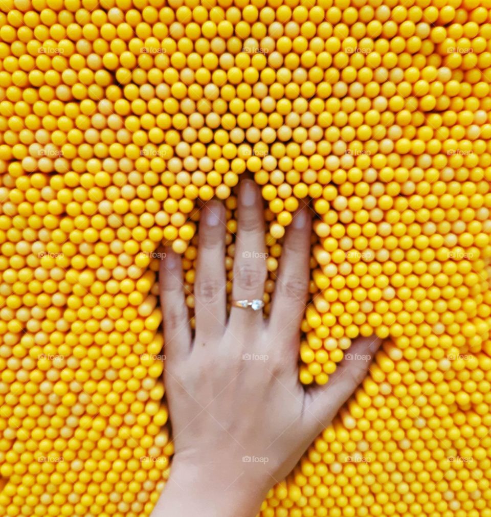 Playing hand on yellow pin screen toy