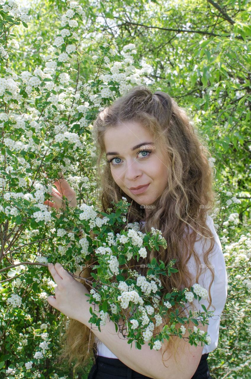 Portrait of Beautiful Young Girl on Flowers Background