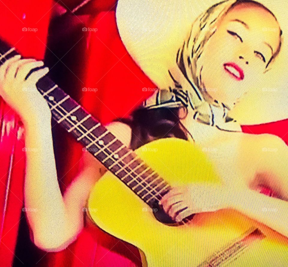 Girl with big hat playing guitar
