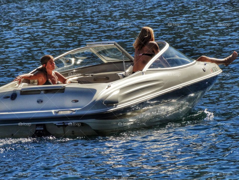 Women Relaxing In A Motorboat. Motorboat On A Lake In Summer