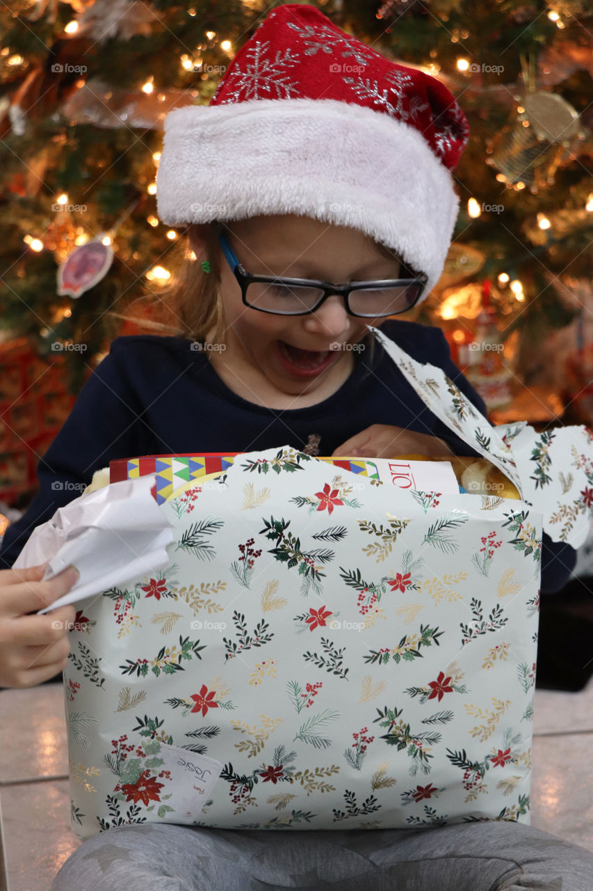 Toddler unwrapping present at Christmas