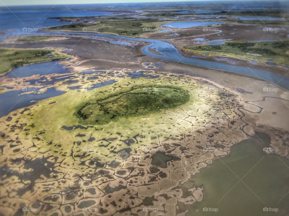 A melting Pingo, seen up from a helicopter. Melting pingos although occurs naturally. Due to increasing global change, we are experiencing high rates of permafrost melting, and melting pingos. Location: Tuktoyaktuk, Northwest Territories, Canada 