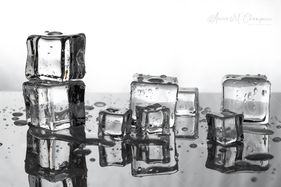 Melting ice cubes leaving liquids and reflections 