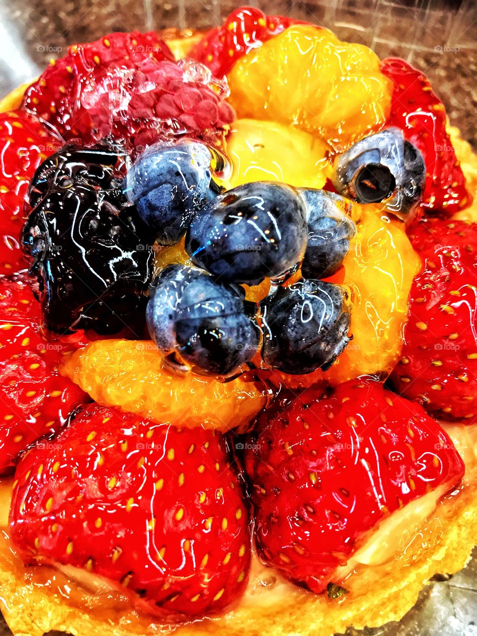 Gourmet fruit tart with strawberries, raspberries, blueberries, mandarines, blackberries, pineapple, and that delicious custard or pastry cream.