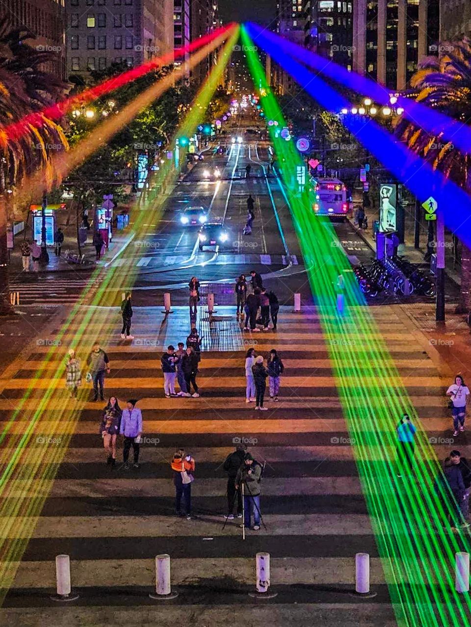 San Francisco Pride 2023 laser light display of the pride flag colors illuminating the sky in front of the Ferry Building on the Embarcadero looking down market street 