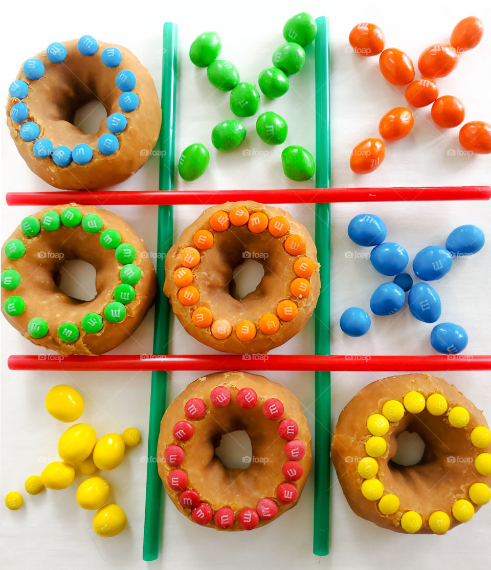 A fun game of Tic-tac-toe. M&M mini decorated donut Os Vs. Peanut M&M Xs.