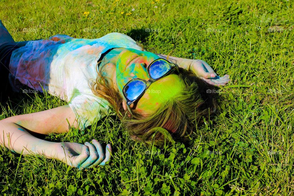 Colored girl lying on green grass.