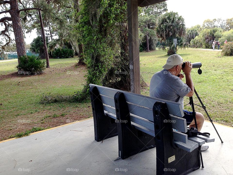 Photographer using a tripod to capture wildlife photos.