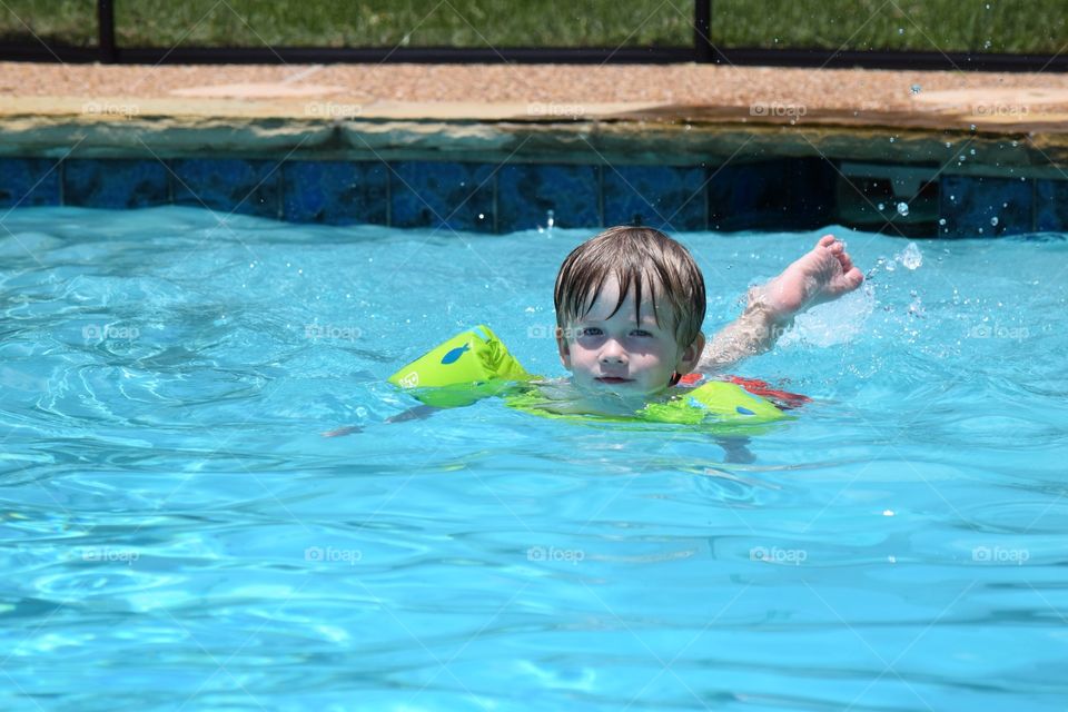 Toddler swimming in a pool