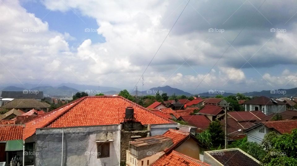 View of residential areas against the background of mountains and panoramic clouds