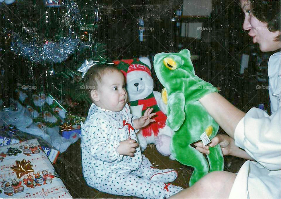 Scary frog puppet. Small child frightened by frog puppet on Christmas morning