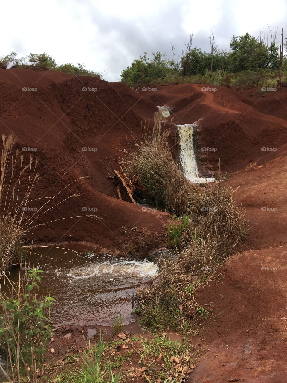 Waterfall over red sand.