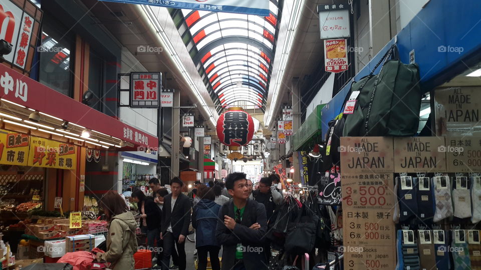 it is kuromon market in osaka japan, u can buy seafood, meat and some cookies here. busy market without fishy smell.
