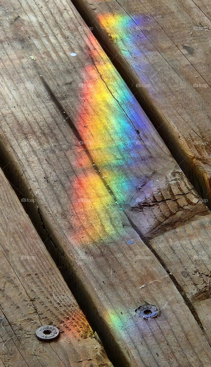 exclamation mark shaped rainbow on wood deck boards