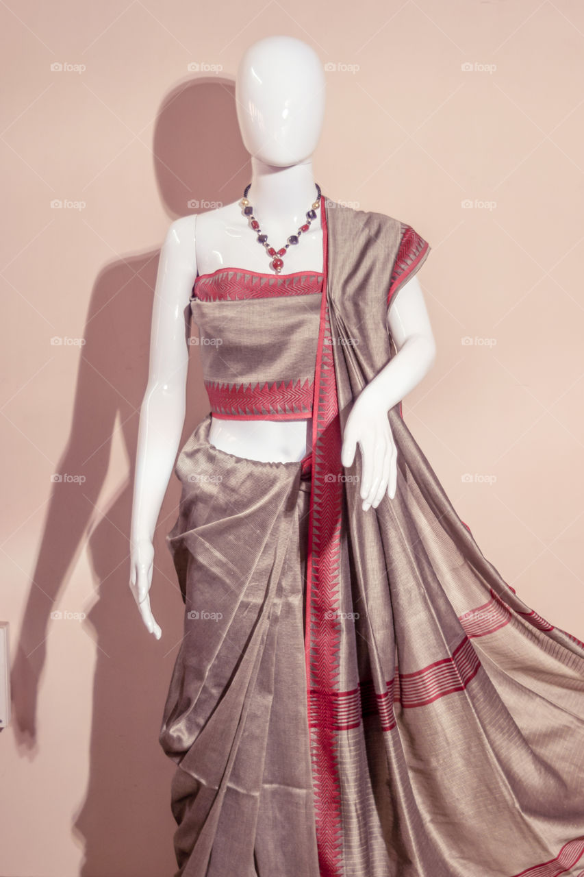 A traditional indian silk saree displayed for sale. Selective focus on model face