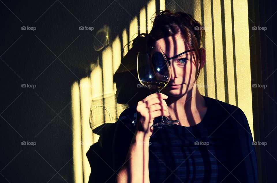 Through the wine glass. Picture of my friend wearing an eyepatch and drinking wine 
