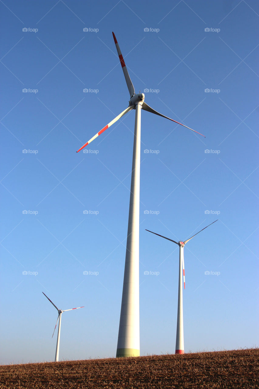 three windmills against blue sky
