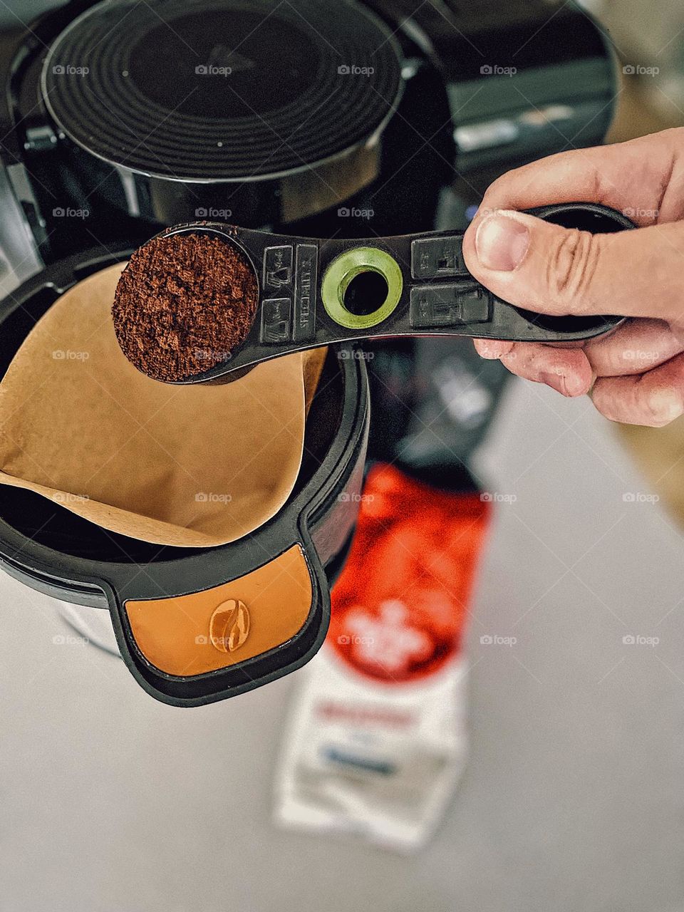 Woman’s hand measures out coffee into coffee maker, making coffee at home, morning daily routines, caffeine in the morning, woman’s hand doing daily routines