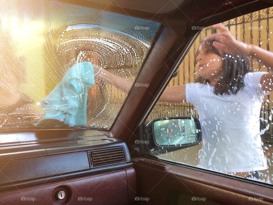 little girl washing grandpa's car