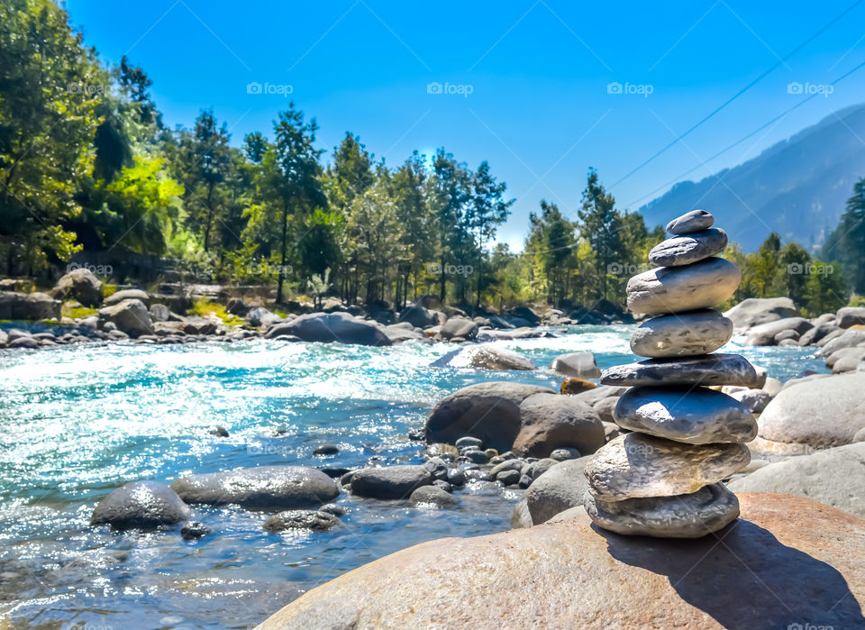 Balance and wellness retro spa concept, inspiration, zen-like and wellbeing tranquil composition. Close-up of white pebbles stack balanced stones on the rocky shore over near river side.