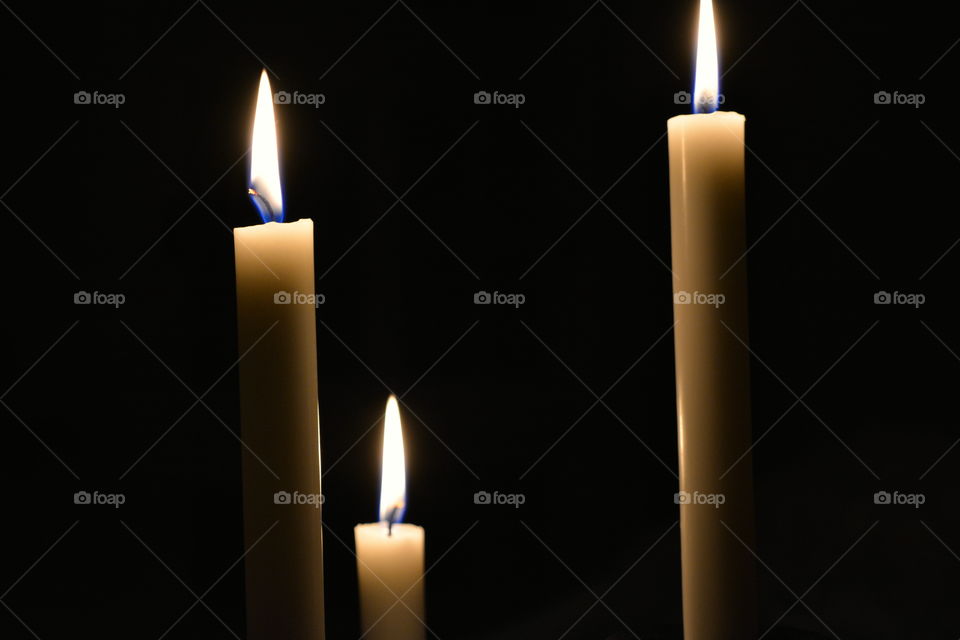Burning candles against black background