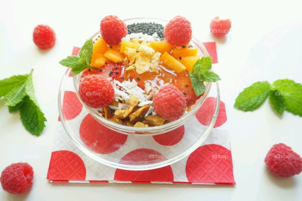 Smoothie fresh fruits bowl - peach, raspberry,  almonds,  strawberries,  coconut,  honey,  seeds and mints