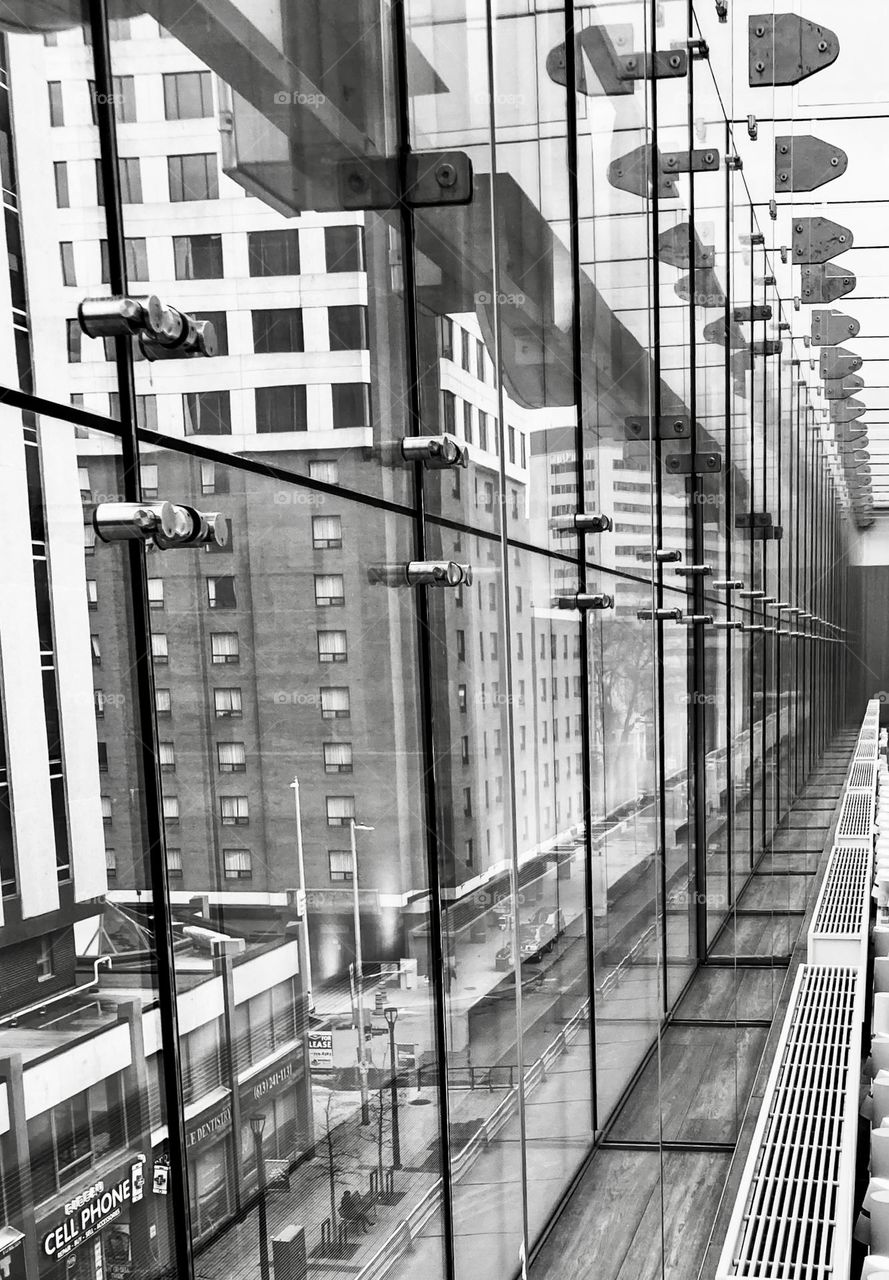 Cityscape through a glass wall filled with leading lines.