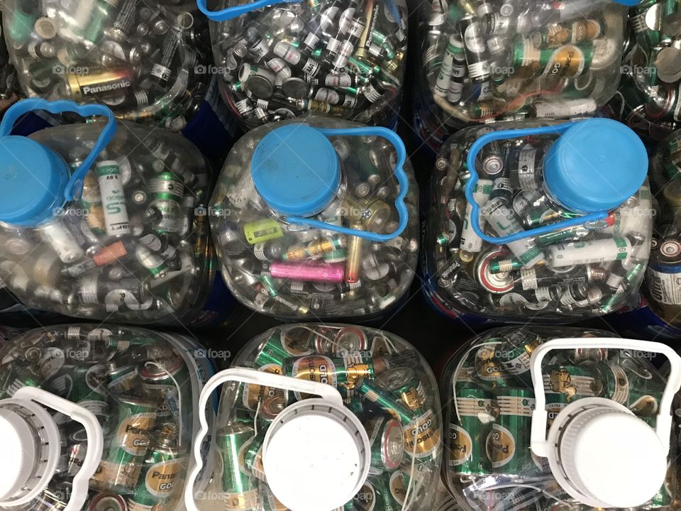collecting many sizes of unused batteries in big plastic bottles which are preparing for recycle or properly destroy