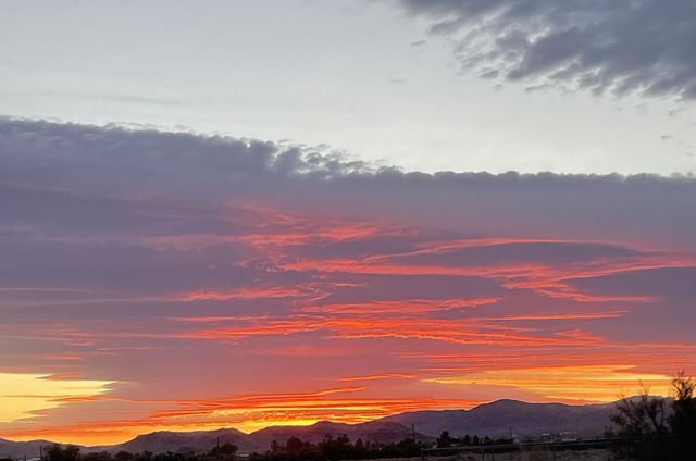 A red, orange, and yellow sunset with mountains. 
