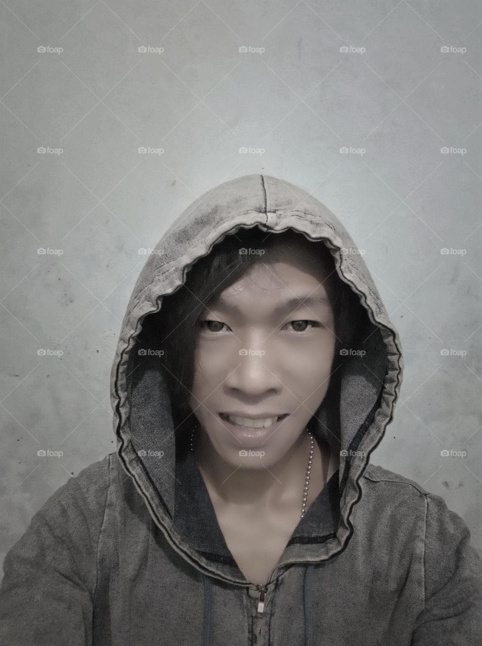 smiling man in hooded sweater jacket