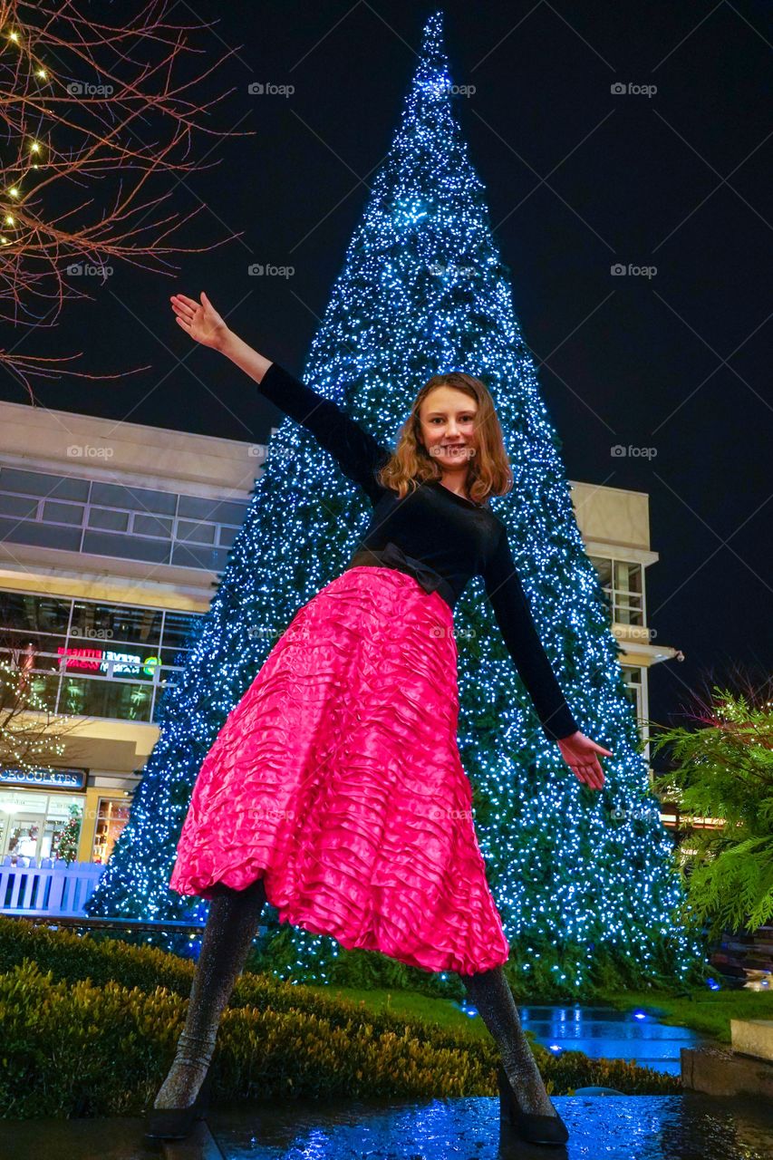 Dance move in front of huge lighted Christmas tree