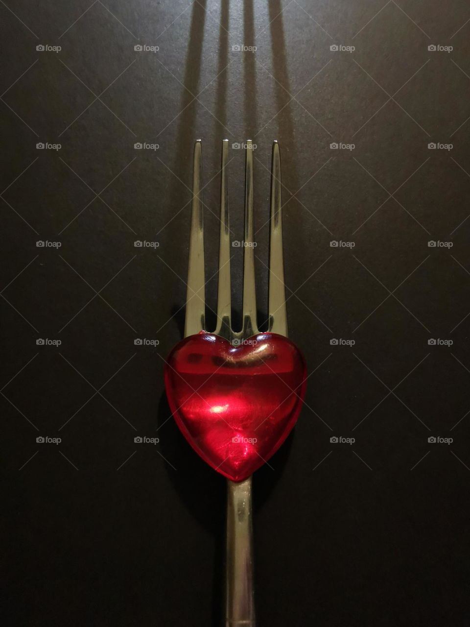 Art photo. Black and red. Fork in the photo. Red heart. Symbolic snapshot "Nourishing with love"...