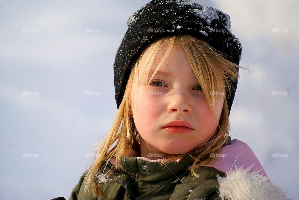 Girl outdoors in the snow looking very serious