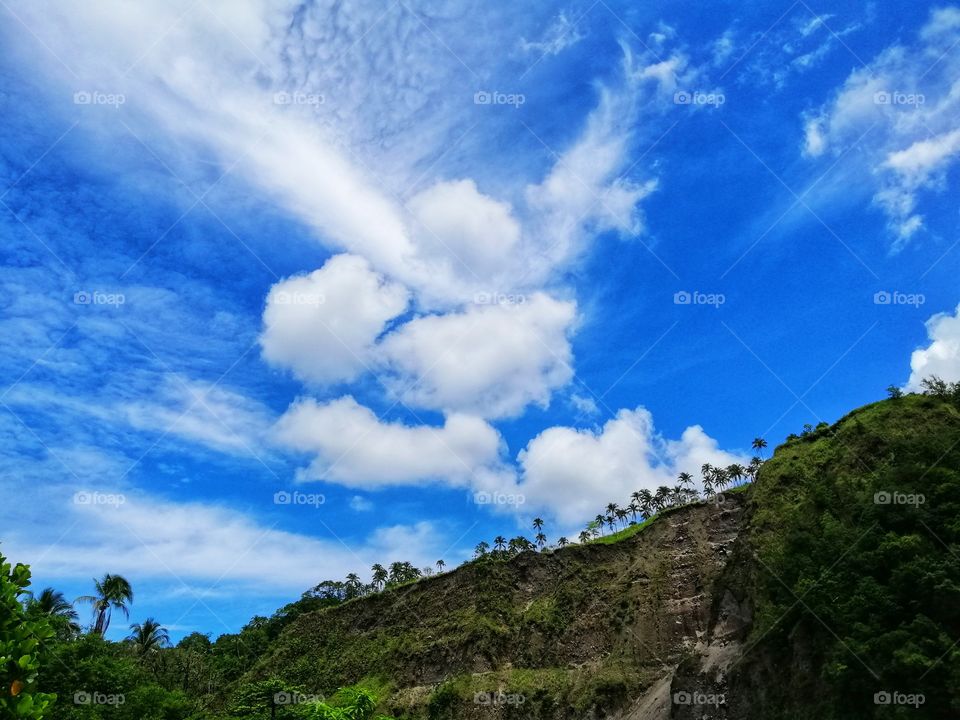 A view of the hill from below with beautiful blue sky and clouds.