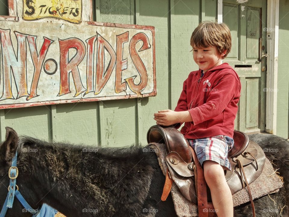 Young Boy Riding A Pony
