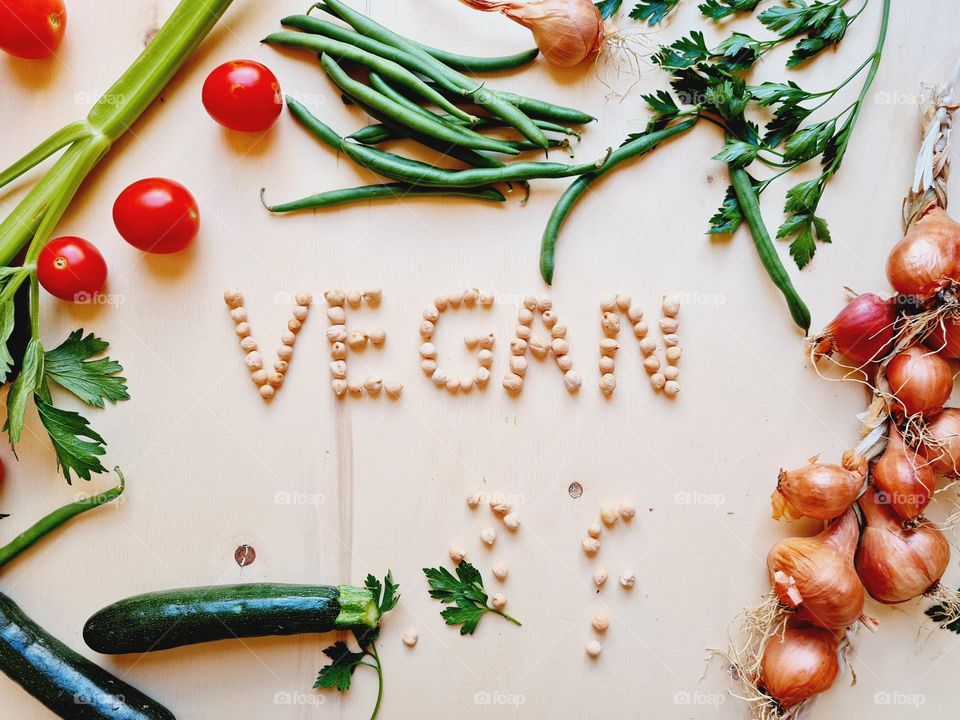 Cutting board with vegetables and vegan written made with chickpeas