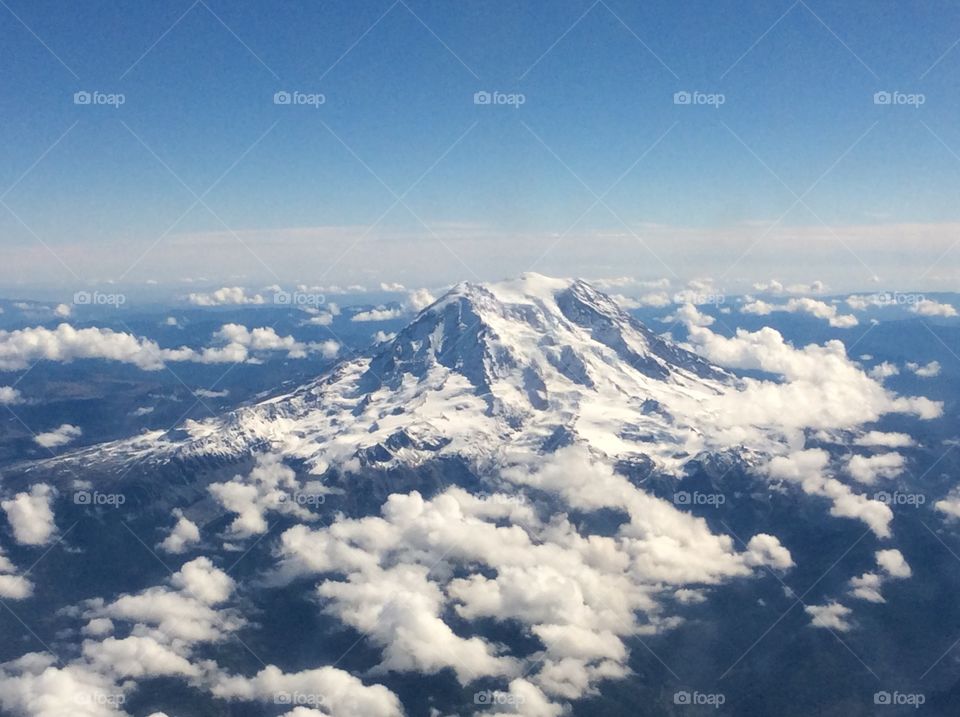 Mt Rainer peaking through the clouds from a flight into SEA