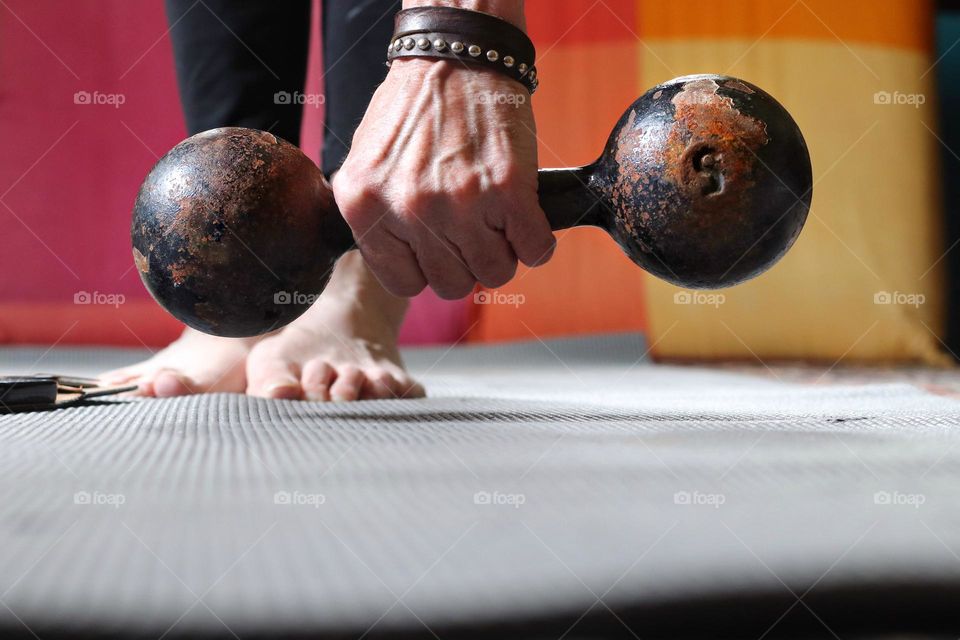 Close-up of a woman's hand holding a rusty dumbbell